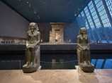 Two Egyptian statues line the approach.